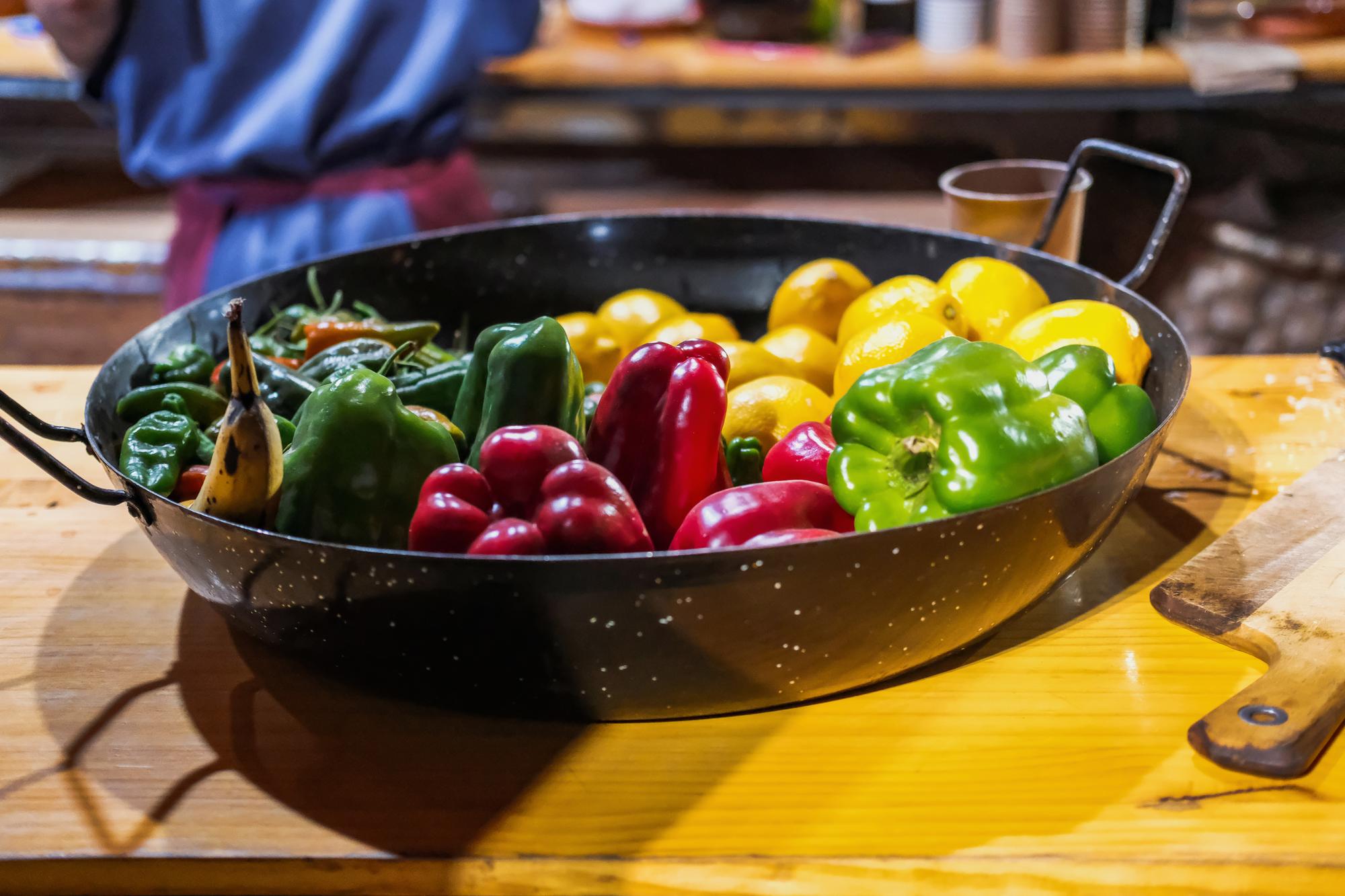 Warm communal kitchen with cast iron pans and fresh produce